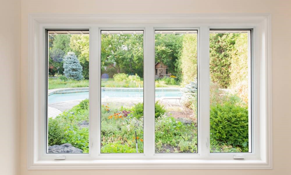 Modern and secure casement windows revealing a lovely view of a residential backyard in the spring.