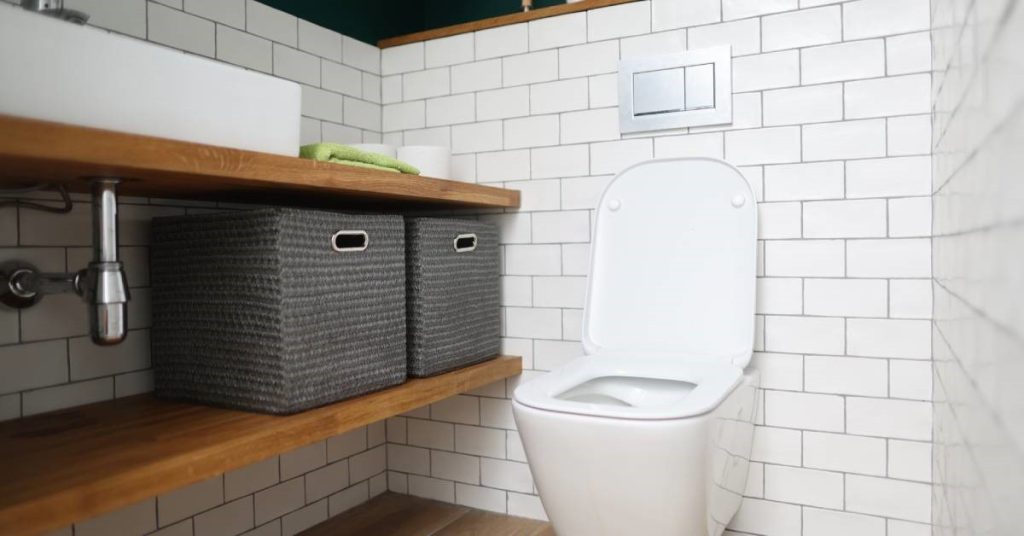 A modern residential bathroom remodel. This restroom features open storage, highlighted by items on counters and in cubbies.