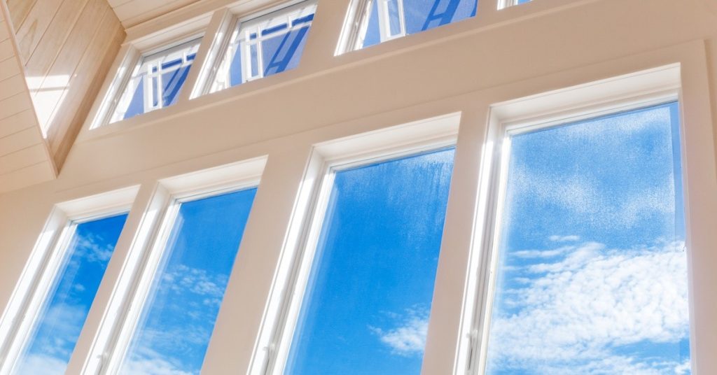 Several windows in a row, each window is looking out to a blue sky. There are some thin clouds in the sky.