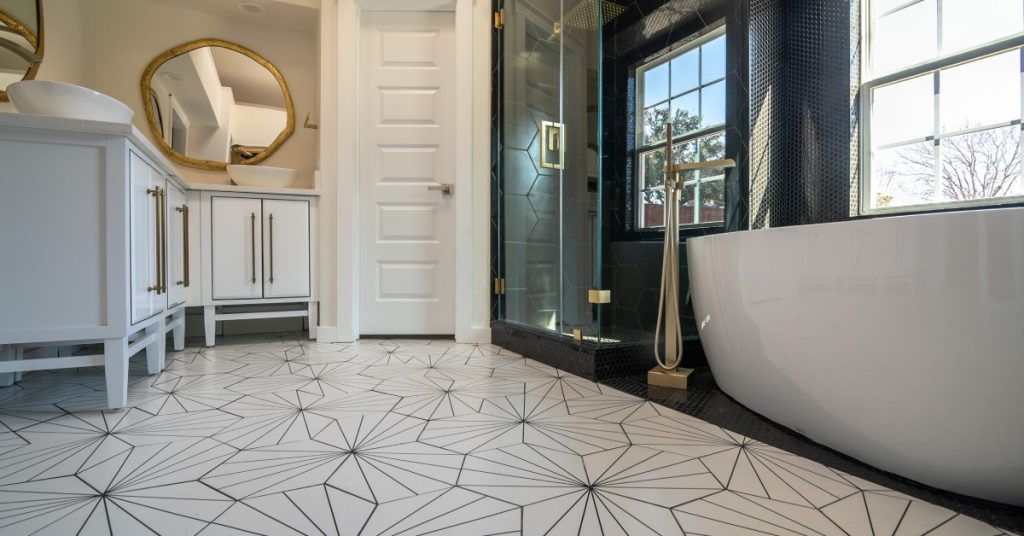 A bathroom with a lot of natural light shining through the a clear window to the right hand side of the frame.