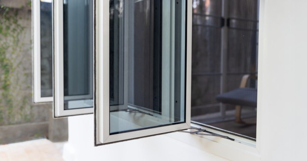 Two windows are installed next to each other on the side of a residential home. There is siding surrounding the windows.